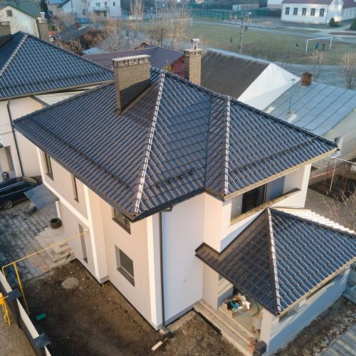 Aerial view of private house with ceramic shingles covered roof top. Investment in real estate concept